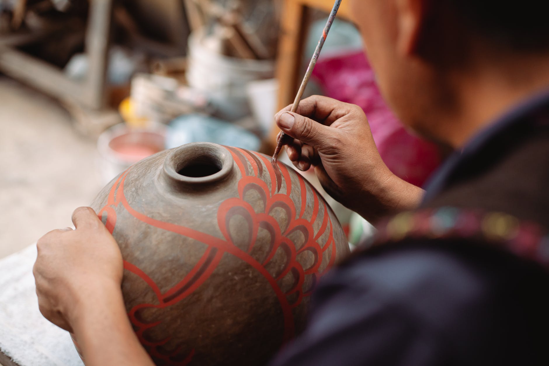 artesano pintando un jarrón de barro
